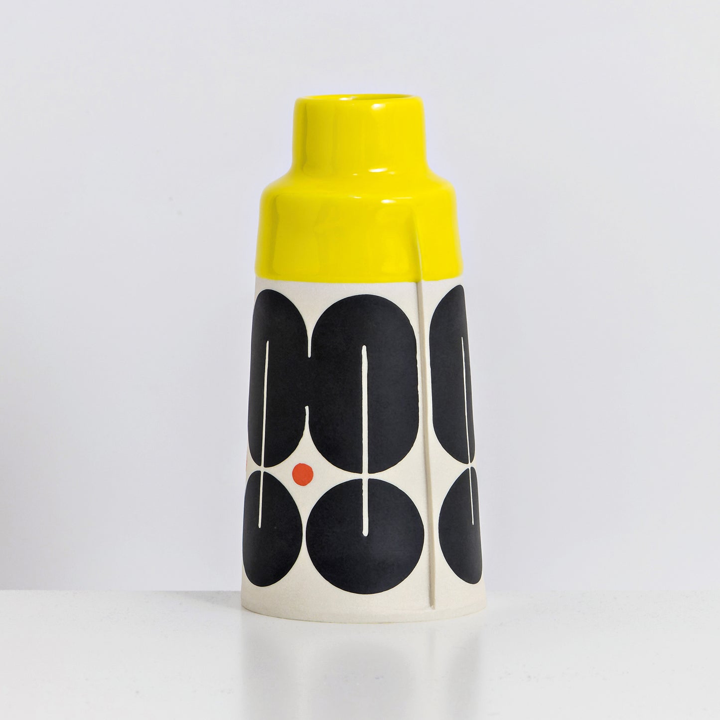 Cone with yellow glaze, shield pattern in red and black