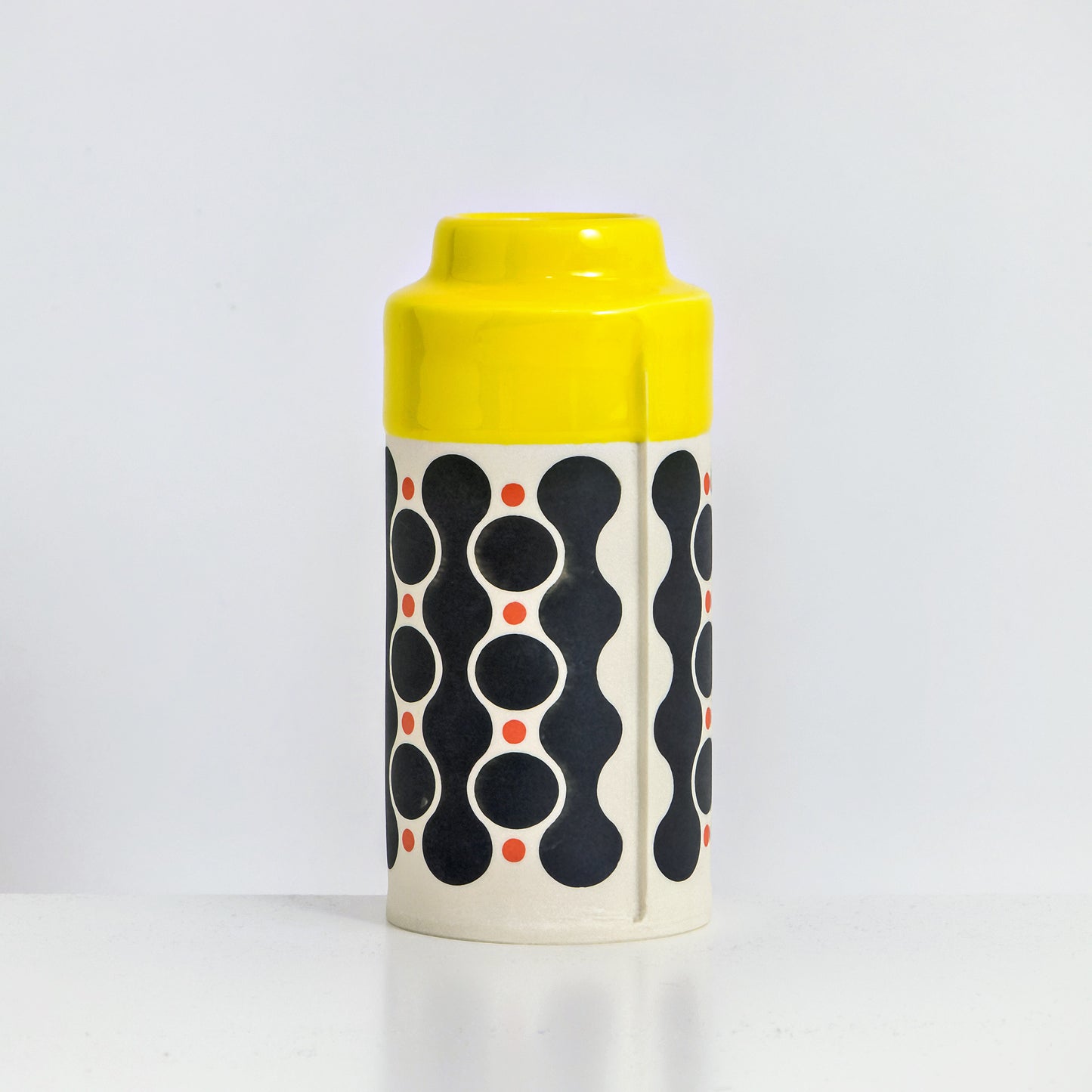 Cylinder with yellow glaze, waterfall pattern in black and red