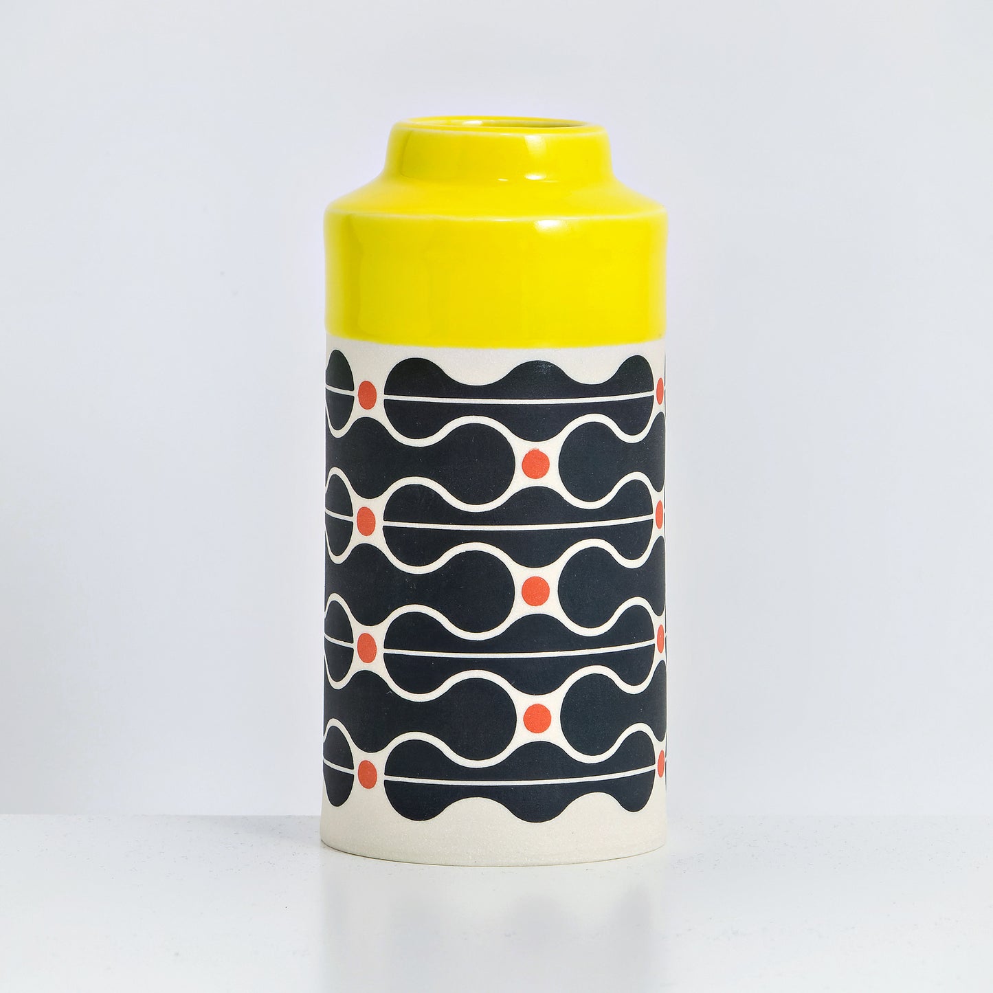 Can with yellow glaze, wave pattern in black and red