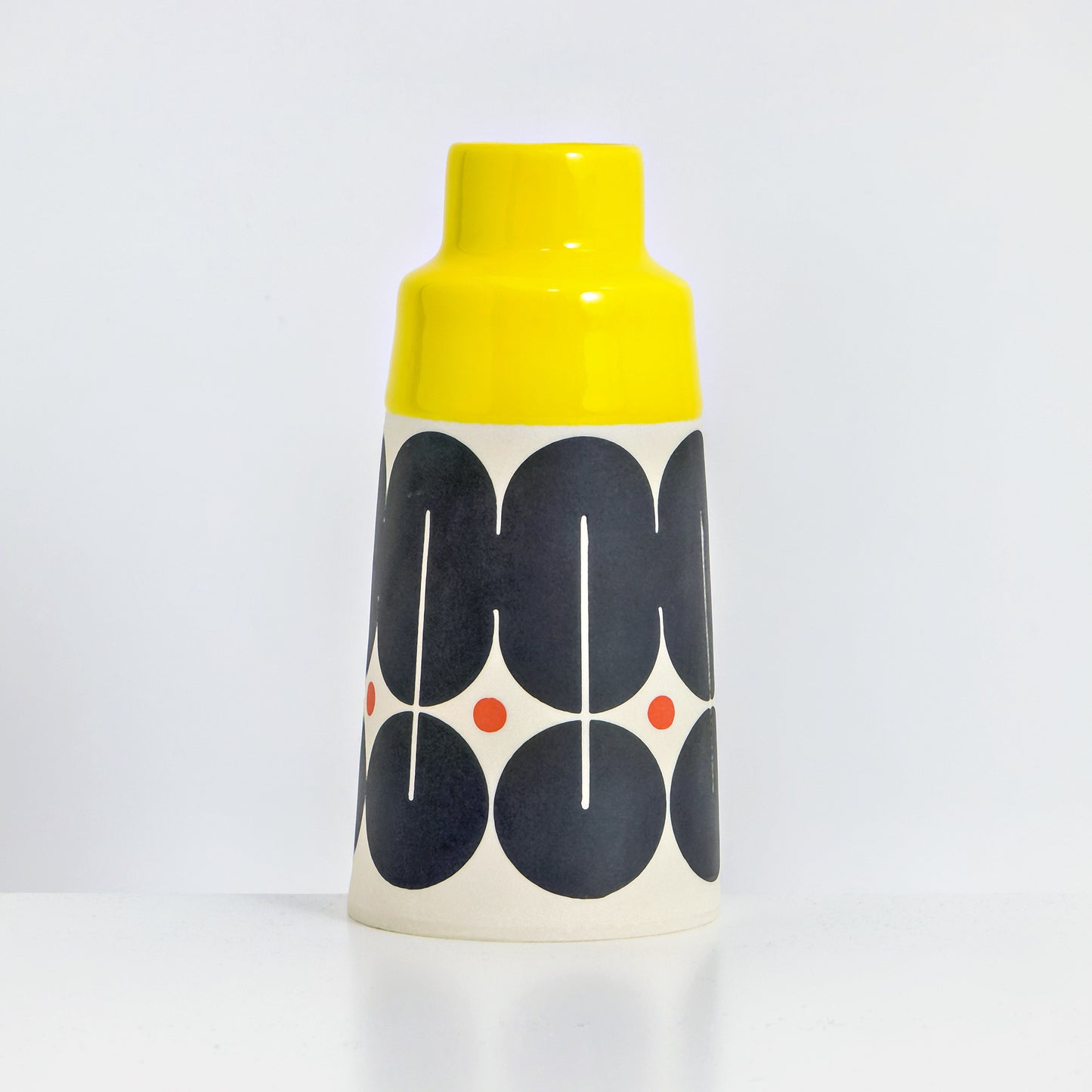 Cone with yellow glaze, shield pattern in red and black