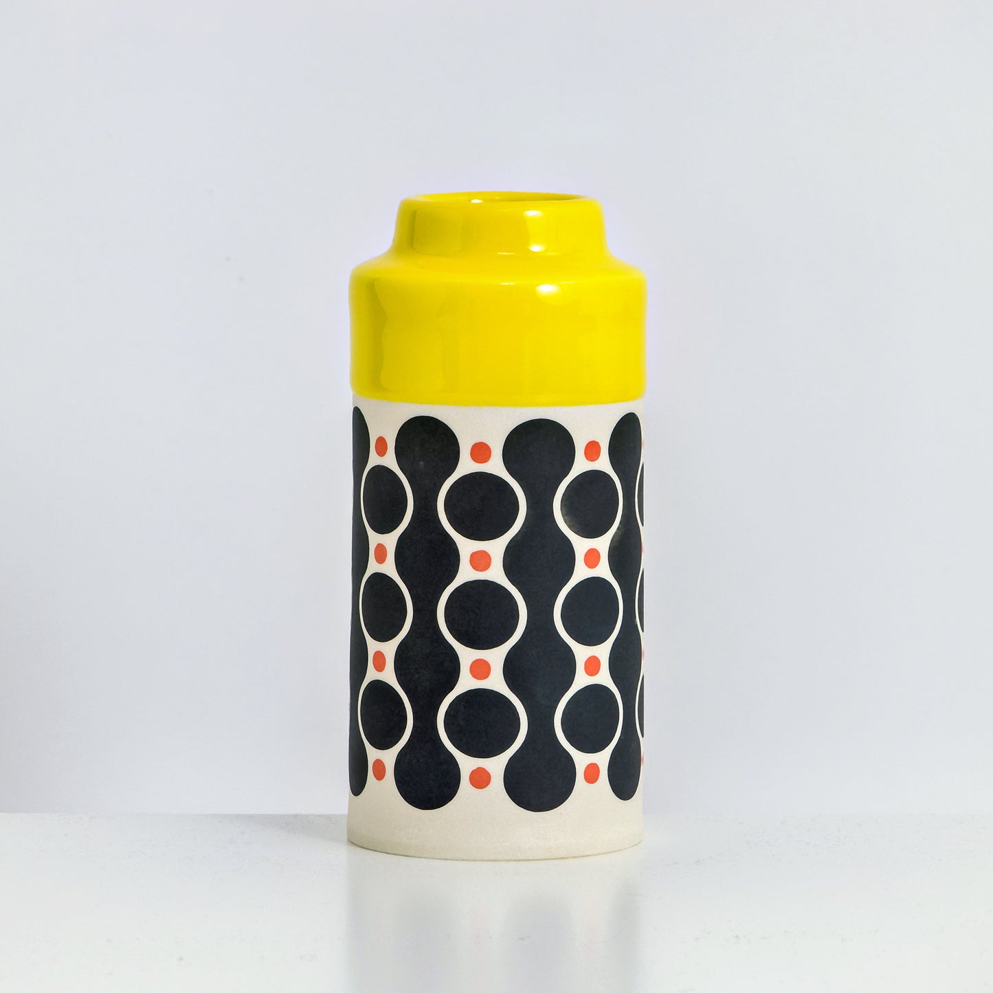 Cylinder with yellow glaze, waterfall pattern in black and red